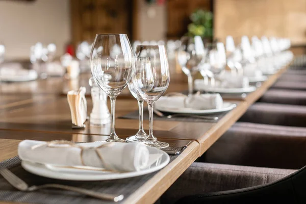 Wine glasses in the foreground. Wedding Banquet or gala dinner. The chairs and table for guests, served with cutlery and crockery. — Stock Photo, Image