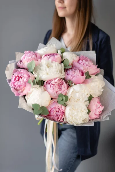 Roze en witte pioenrozen in dames handen. Mooie Peony bloem voor de catalogus of online winkel. Bloemenwinkel concept. Mooie vers gesneden boeket. Bloemen bezorgen — Stockfoto