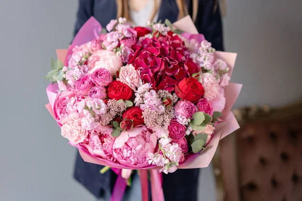 Pink peonies and red hydrangea. Beautiful bouquet of mixed flowers in woman hand. Floral shop concept . Handsome fresh bouquet. Flowers delivery. Red and pink color. — Stock Photo, Image