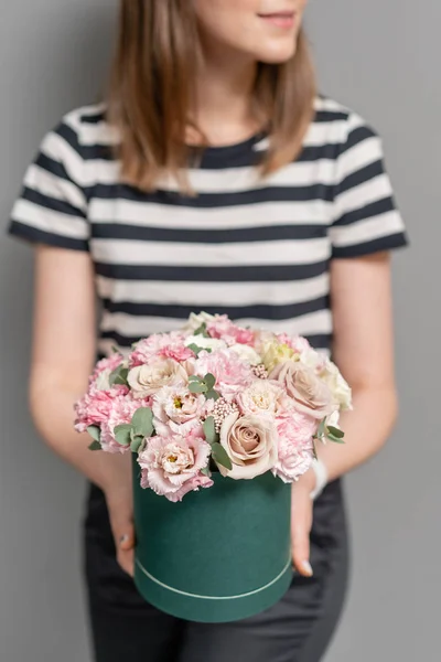 Lindo arreglo floral de flores mixtas en mano de mujer. Caja redonda. El trabajo de la floristería en una florería. Delicado color pastel. Flor fresca cortada . — Foto de Stock