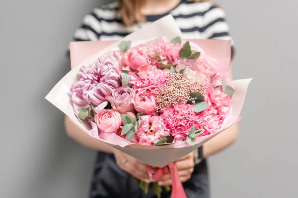 Bellissimo bouquet di fiori misti nelle mani delle donne. il lavoro del fioraio in un negozio di fiori. Colore pastello delicato. Fiore reciso fresco. Colore rosa — Foto Stock