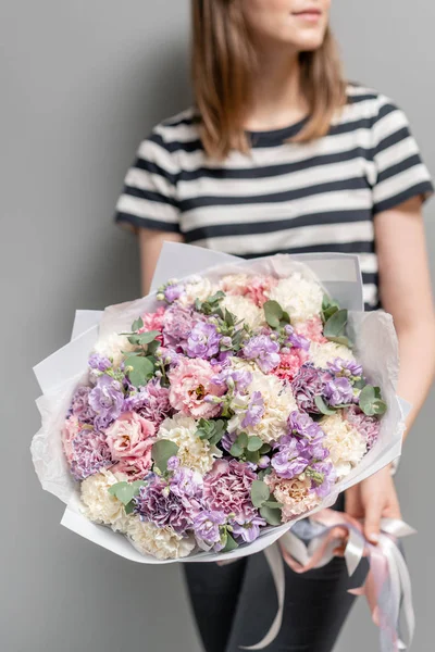 Bellissimo bouquet di fiori misti nelle mani delle donne. il lavoro del fioraio in un negozio di fiori. Colore pastello delicato. Fiore tagliato fresco . — Foto Stock