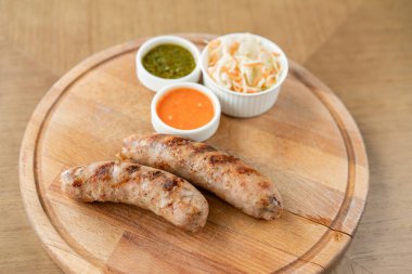 Izgara sosisler. Tahta bir tahtada hizmet veriyor. Barbekü restoran menüsü, farklı etfotoğrafları bir dizi. Lahana turşusu ve iki sos