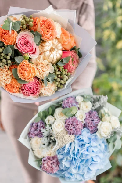 两束美丽的混合花在女人手中。花店花店的工作。鲜切花. — 图库照片