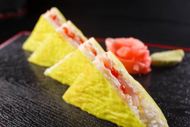 Üçgen parçalar. Japon yemekleri, öğle yemeğinde lezzetli yemek. Deniz ürünleri. Suşi, balık, alabalık, ton balığı siyah arka plan ile.