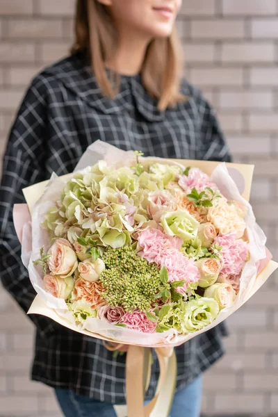 Pink and green color. Beautiful bouquet of mixed flowers in womans hands. the work of the florist at a flower shop. Fresh cut flower. — Stock Photo, Image