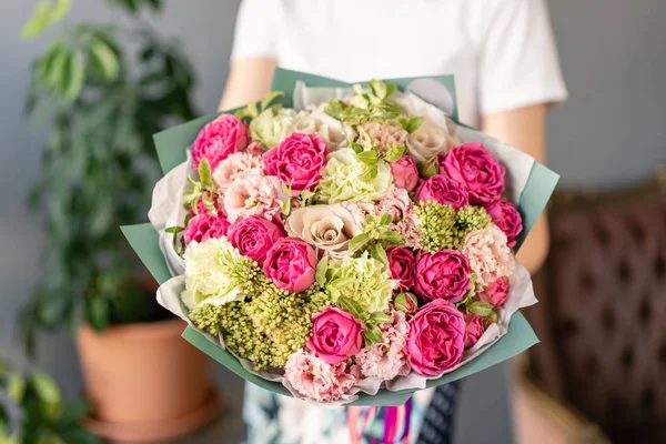 Beautiful bouquet of mixed flowers in womans hands. the work of the florist at a flower shop. Fresh cut flower. — Stock Photo, Image