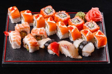 Japon yemekleri, lezzetli yemek yemek için. Deniz ürünleri. Suşi yılan balığı, somon, alabalık, ton balığı siyah arka plan.