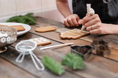 Bir sürü kahverengi ahşap masa Avrupa evler şeklinde zencefilli bisküvi. Beyaz tatlı sır ile dekore edilmiştir. Noel ruh hali, kış sabahı.