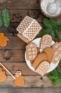 Bir sürü kahverengi ahşap masa Avrupa evler şeklinde zencefilli bisküvi. Beyaz tatlı sır ile dekore edilmiştir. Noel ruh hali, kış sabahı.