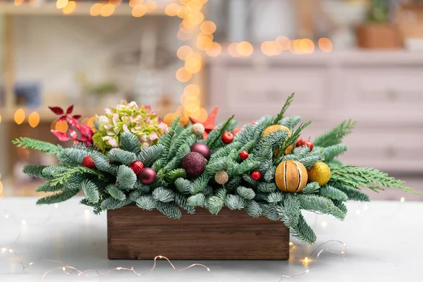 Belo arranjo festivo de abeto fresco com brinquedos de bola em uma caixa de madeira rústica. Humor de Natal. Bokeh de luzes de guirlanda no fundo. — Fotografia de Stock