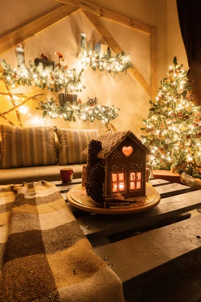 Julafton i vardagsrummet.. Hemlagad pepparkakshus på bakgrundsrum dekorerad till jul. — Stockfoto