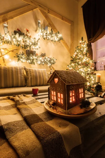 Julafton i vardagsrummet.. Hemlagad pepparkakshus på bakgrundsrum dekorerad till jul. — Stockfoto