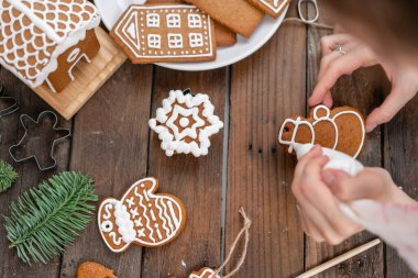 Noel ekmek krema. Bal gingerbread çerezleri üzerinde ahşap kahverengi masa dekorasyon kadın. portre, kopya alanı. Boş Bisküvi Kurabiye evi, süslemek hazır.