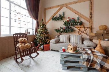 Parlak oturma odasında Noel sabahı. Noel için dekore edilmiş arka plandaki ev yapımı zencefilli kurabiye evi..