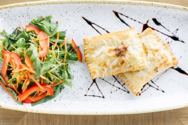Latin Amerika kızarmış börekleri ile sebze salatası ve roka. Balzamik sosla süslenmiş. Menü Restoranı