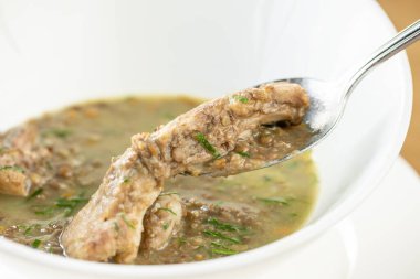 Bir kase ev yapımı kırmızı biberli mercimek çorbası ve ahşap masa. Restoran menüsü