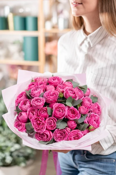 Lotes de botões Rosas de cor rosa fúcsia. Buquê na mão da mulher. o trabalho da florista em uma loja de flores Floricultura conceito — Fotografia de Stock