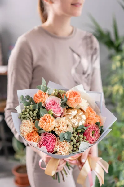 Beau bouquet de fleurs mélangées dans les mains des femmes. le travail du fleuriste dans un magasin de fleurs. Fleurs fraîches coupées . — Photo