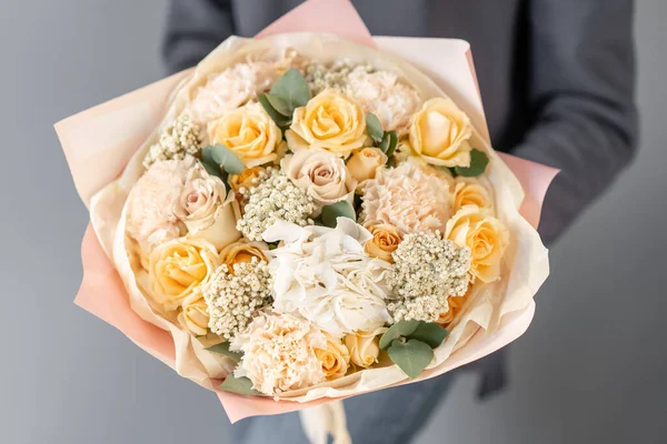 Hermoso ramo de flores mixtas en manos de mujeres. el trabajo de la floristería en una florería. Flor fresca cortada . — Foto de Stock