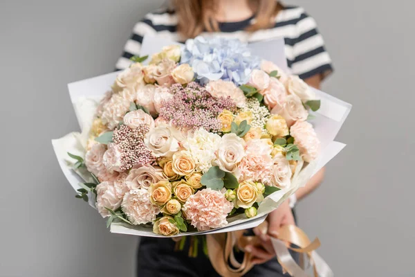 Multicolor. Hermoso ramo de flores mixtas en manos de mujeres. el trabajo de la floristería en una florería. Flor fresca cortada . — Foto de Stock