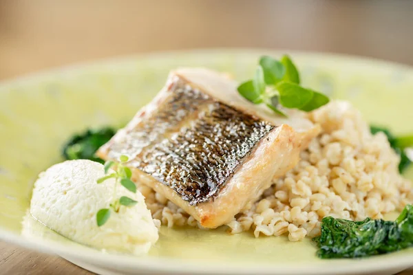 Roasted pike perch or cod fish with bulgur. Dish decorated with a spinach. Restaurant menu — Stock Photo, Image
