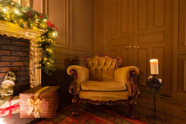 Świąteczny wieczór przy świecach. klasyczne apartamenty z kominkiem, urządzone drzewo, fotel. — Zdjęcie stockowe