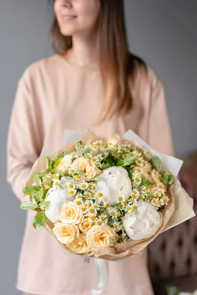 Pequeño hermoso ramo de flores mixtas en mano de mujer. Concepto de tienda floral. Entrega de flores. Peonías blancas — Foto de Stock