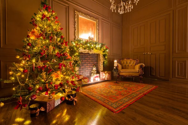 Julafton med levande ljus. klassiska lägenheter med öppen spis, dekorerat träd, fåtölj. — Stockfoto