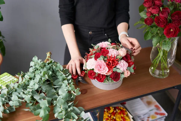 Mujer florista crea arreglo floral en una caja redonda. Hermoso ramo de flores mixtas. Concepto de tienda floral. Hermoso grupo fresco. Entrega de flores — Foto de Stock