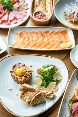 Restoranda et tartarı var. Tabakların çeşitleri masada. Masada çeşitli abur cuburlar ve antipastalar var. Restoran menüsü. İtalyan mutfağı