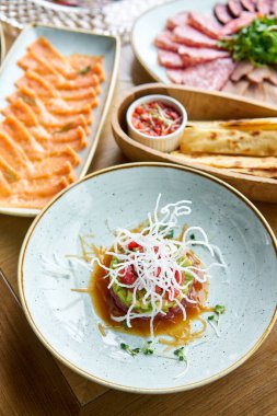 Restorandaki ton balıklı tartar. Tabakların çeşitleri masada. Masada çeşitli abur cuburlar ve antipastalar var. Restoran menüsü. İtalyan mutfağı