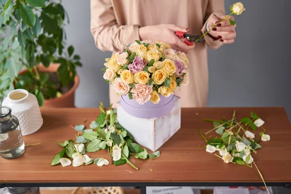 Mujer florista crea arreglo floral en una caja redonda. Hermoso ramo de flores mixtas. Concepto de tienda floral. Hermoso grupo fresco. Entrega de flores — Foto de Stock