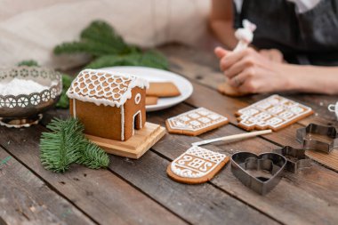 Bir sürü kahverengi ahşap masa Avrupa evler şeklinde zencefilli bisküvi. Beyaz tatlı sır ile dekore edilmiştir. Noel ruh hali, kış sabahı.