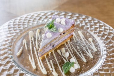 Kremalı ve nane yapraklı yaban mersinli kek. Kafede kahvaltı, sabah kahvesi. Tahta masada. Restoran menüsü