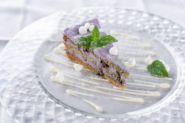 Kremalı ve nane yapraklı yaban mersinli kek. Kafede kahvaltı, sabah kahvesi. Tahta masada. Restoran menüsü