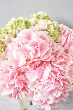 Masadaki vazoda duran güzel pembe ortanca çiçekleri. Açık pembe çiçek buketi. Evin dekorasyonu. Duvar kağıdı ve arkaplan.