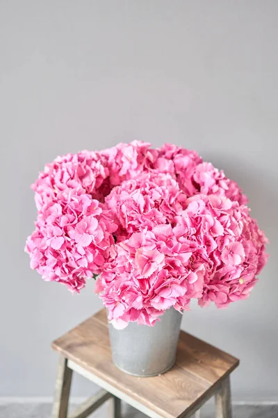 Beautiful pink hydrangea flowers in a vase on a table . Bouquet of light pink flower. Decoration of home. Wallpaper and background. fuchsia color