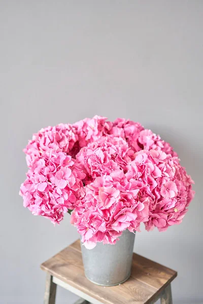 Beautiful pink hydrangea flowers in a vase on a table . Bouquet of light pink flower. Decoration of home. Wallpaper and background. fuchsia color
