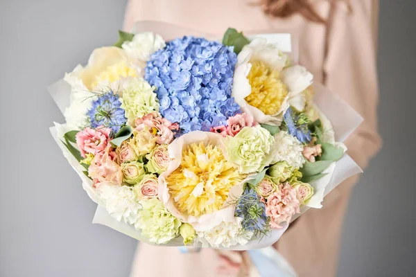 Peonies and hydrangea. Beautiful bouquet of mixed flowers in woman hand. Floral shop concept . Handsome fresh bouquet. Flowers delivery.