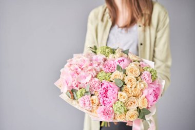 Pembe şakayıklar ve ortancalar. Kadın elinde güzel bir buket karışık çiçek. Çiçek dükkanı konsepti. Güzel, taze bir buket. Çiçek teslimatı.