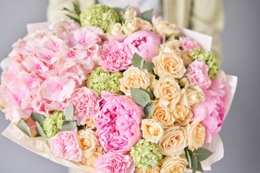 Yakın plan Pembe şakayıklar ve ortancalar. Kadın elinde güzel bir buket karışık çiçek. Çiçek dükkanı konsepti. Güzel, taze bir buket. Çiçek teslimatı.