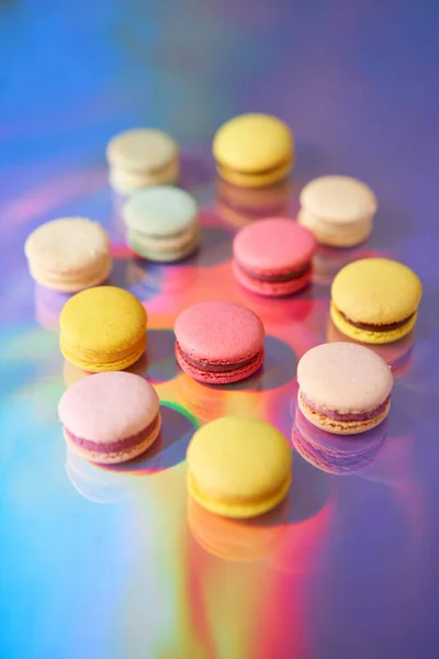 Macaron alla francese. Set di dolci carino su sfondo arcobaleno colorato. biscotti alle mandorle, colori pastello, vista dall'alto — Foto Stock