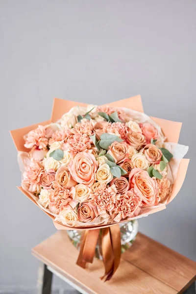Bouquet Peach and orange color. Beautiful bunch mixed flowers in wooden table. the work of the florist at a flower shop. Fresh cut flower. — Stock Photo, Image
