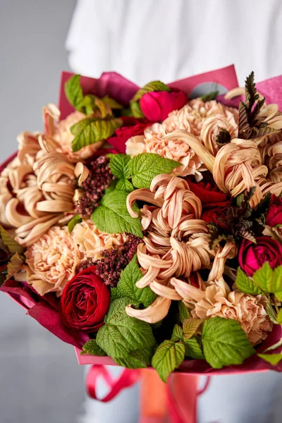 Rottöne Schöner Strauß gemischter Blumen in Frauenhänden. die Arbeit des Blumenhändlers in einem Blumenladen. Schöner frischer Strauß. Blumenlieferung — Stockfoto