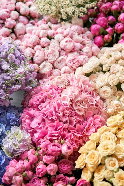 Muchos colores diferentes en el soporte o mesa de madera en la florería. Escaparate. Fondo de mezcla de flores. Hermosas flores para catálogo o tienda en línea. —  Fotos de Stock