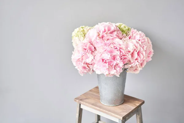 Hermosas flores de hortensias rosadas en un jarrón sobre una mesa. Ramo de flores de color rosa claro. Decoración del hogar. Fondo de pantalla y fondo. — Foto de Stock