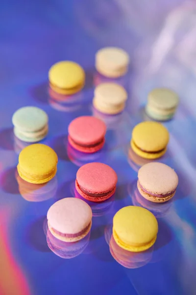 Macaron alla francese. Set di dolci carino su sfondo arcobaleno colorato. biscotti alle mandorle, colori pastello, vista dall'alto — Foto Stock