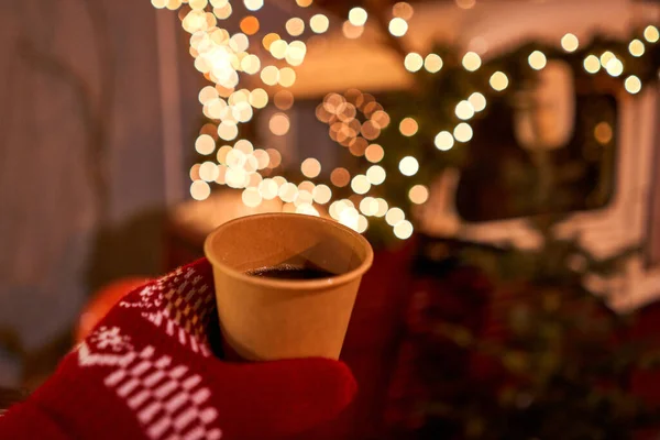 Mercado de Natal na pequena cidade europeia. Mão segurando uma xícara de vinho quente com fundo borrado de país das maravilhas do inverno, um — Fotografia de Stock