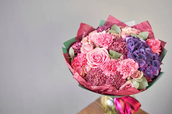 Фиолетовый и розовый букет красивых цветов на деревянном столе. Концепция флористики. Весенние цвета. работа флориста в цветочном магазине. — стоковое фото